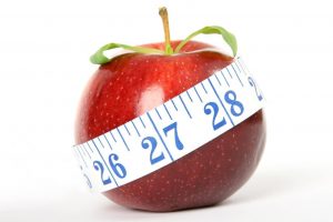 A Red Apple Wrapped With Measurement Tape